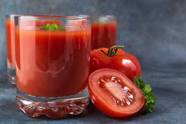 Bardakta domates suyu. Mavi mahsul arka plan. Taşralı. Fotoğraf.