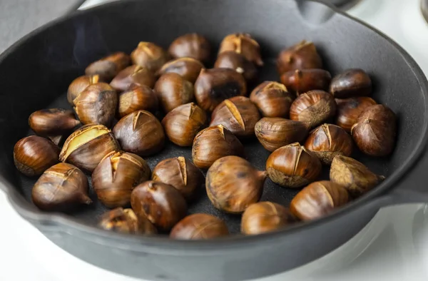 Ripe chestnuts are fried in a pan. the process of cooking chestnuts. Delicious delicacy. — Stock Photo, Image