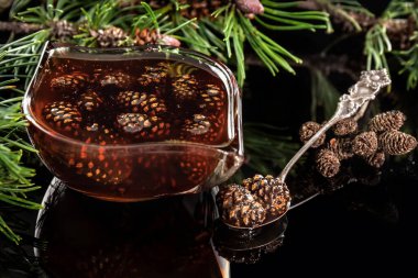 Cam bardakta çam kozalağı reçeli. Kaşıkta çam kozalakları. Sağlıklı yemek..