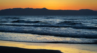 Deniz kıyısında gün batımı. Gün batımında deniz dalgaları. Fotoğraf.