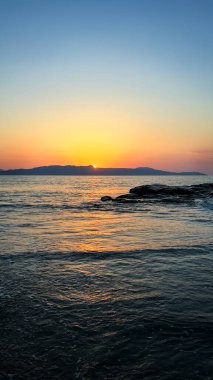 Deniz kıyısında gün batımı. Gün batımında deniz dalgaları. Fotoğraf.