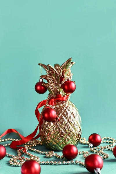 Gouden Ananas Versierd Met Rode Kerstbal Linten Bloemenslingers Een Blauwe — Stockfoto