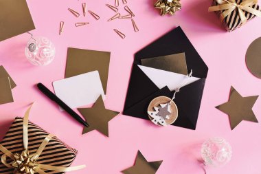 Siyah zarf, kağıt kartlar ve pembe arka planda altın renkli kartlar. Noel mektubu konsepti. Noel davetiyesi düzdü. Kış tatili