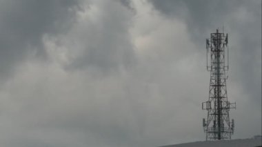 Gökyüzündeki büyük iletişim kulesi ve arka plandaki bulutlar 