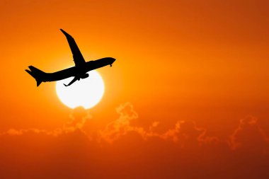 Havaalanından kalkan yolcu uçağının silüeti. Covid-19 krizinden sonra turist uçuşları