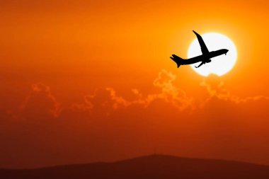 Havaalanından kalkan yolcu uçağının silüeti. Covid-19 krizinden sonra turist uçuşları