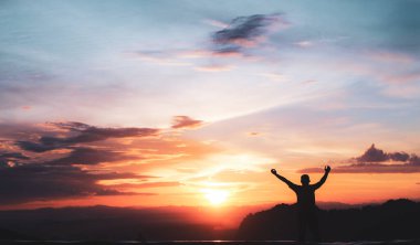 Akşamları güzel bir gün batımı manzaralı bir turistin silueti..