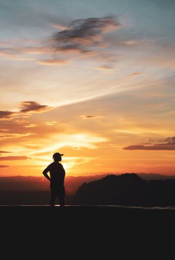 Akşamları güzel bir gün batımı manzaralı bir turistin silueti..