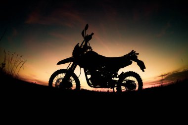 Akşamları dağdaki turist motosikletli siluet parkında. macera yolculuğu konsepti