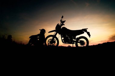 Erkek siluetleri ve motosiklet turları. Akşam dağlarda dinlenmek için park et. macera seyahati ve eğlence konsepti