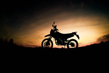 Akşamları dağdaki turist motosikletli siluet parkında. macera yolculuğu konsepti