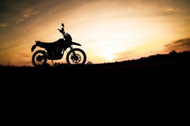Akşamları dağdaki turist motosikletli siluet parkında. macera yolculuğu konsepti