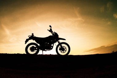 Akşamları dağdaki turist motosikletli siluet parkında. macera yolculuğu konsepti