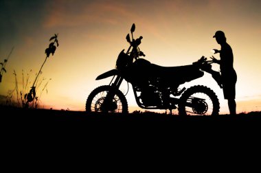 Siluet Adam güzel bir ışık akşamında kırsal alanda cep telefonu kullanıyor..