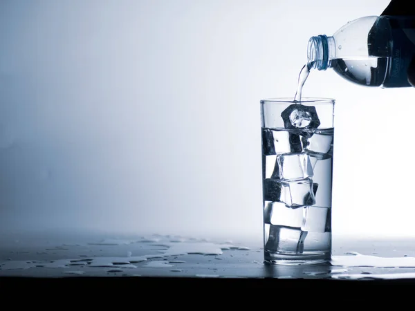 人们把瓶子里的水倒入一杯冰镇干净的饮用水中 健康饮水概念 — 图库照片