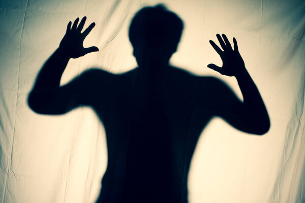 frightening ghost in a white sheet nightmare. scary picture of hands behind curtain. halloween idea