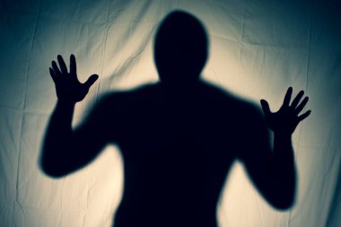 Beyaz bir çarşaf içinde korkunç bir hayalet. Perdenin arkasındaki ellerin korkunç resmi. Cadılar Bayramı fikri