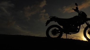 Akşamları bir motokros motosikleti silueti. Macera Gezgini konsepti