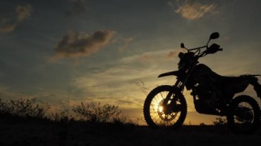 Akşamları bir motokros motosikleti silueti. Macera Gezgini konsepti