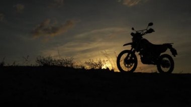 Akşamları bir motokros motosikleti silueti. Macera Gezgini konsepti
