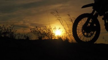 Akşamları bir motokros motosikleti silueti. Macera Gezgini konsepti