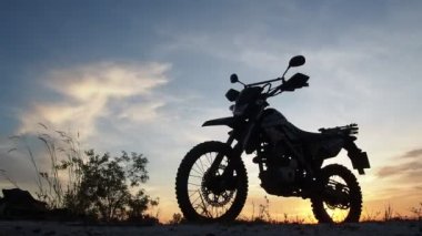 Akşamları bir motokros motosikleti silueti. Macera Gezgini konsepti