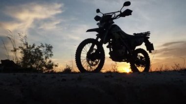 Akşamları bir motokros motosikleti silueti. Macera Gezgini konsepti