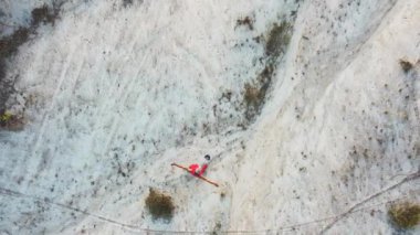 Kırmızı spor giysili Asyalı adam dağlarda koşuyor ve antrenman yapıyor.
