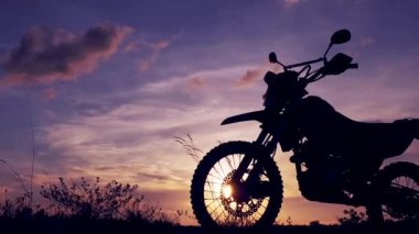 Akşamları bir motokros motosikleti silueti. Macera Gezgini konsepti
