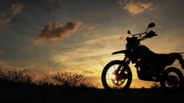 Akşamları bir motokros motosikleti silueti. Macera Gezgini konsepti