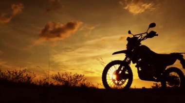 Akşamları bir motokros motosikleti silueti. Macera Gezgini konsepti