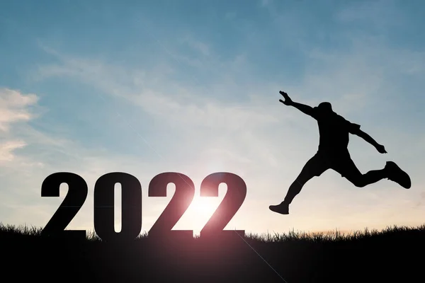 2022年の新年のコンセプト 男のシルエットが自由に楽しくジャンプ — ストック写真