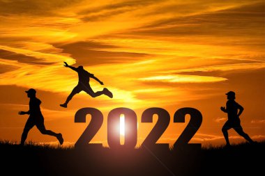 Mutlu yıllar 2022 konsepti. Özgürce ve mutlu atlayan bir adamın silüeti..