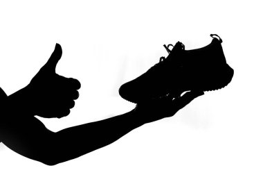 Beyaz arka planda koşan bir ayakkabıyı tutan bir adamın silueti. Koşu ayakkabısı almak ve egzersiz yapmak için fikirler.