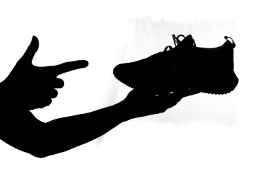 Beyaz arka planda koşan bir ayakkabıyı tutan bir adamın silueti. Koşu ayakkabısı almak ve egzersiz yapmak için fikirler.