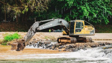 Kazı makinası kanalda çalışıyor. Bir kazıcı Tayland 'da bir kanal kazıyor, 29 Aralık 2021, Ban Na San Bölgesi, Surat Thani Eyaleti, Tayland.