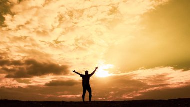 Erkeklerin siluetleri son derece mutlu. Erkek silueti, ellerini neşe ve özgürlükle kaldırıyordu. özgürlük kavramı