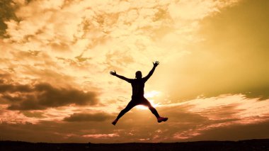Erkeklerin siluetleri son derece mutlu. Erkek silueti, ellerini neşe ve özgürlükle kaldırıyordu. özgürlük kavramı