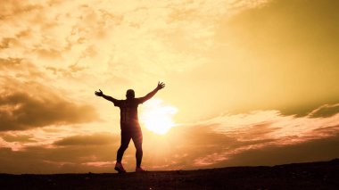 Erkeklerin siluetleri son derece mutlu. Erkek silueti, ellerini neşe ve özgürlükle kaldırıyordu. özgürlük kavramı