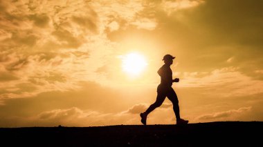 Erkek silueti. Akşamları sağlıklı kalmak için koşuyorum. Erkekler koşarak egzersiz yapar. sağlık hizmeti kavramı