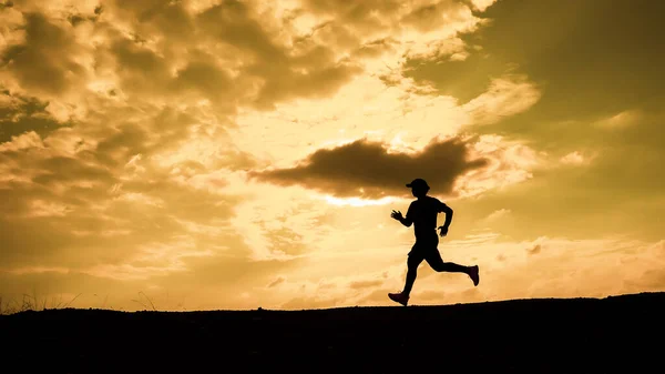 男性のシルエット私は夕方に健康を維持するためにジョギングしています 男は走ることによって運動する ヘルスケアの概念 — ストック写真