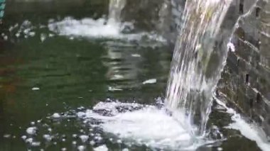 water flowing through the pond on background