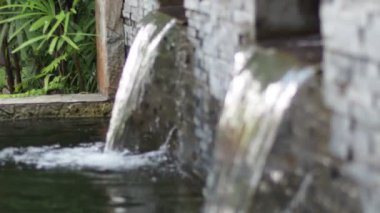 water flowing through the pond on background