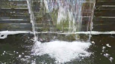 water flowing through the pond on background