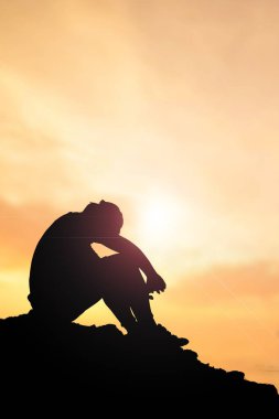 İşsiz bir adam, başı eğik, umutsuzca oturdu..