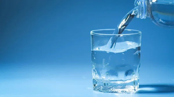 工作室拍摄干净的饮用水倒入玻璃和天然蓝色背景 健康饮水概念 — 图库照片