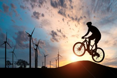 Arka planda batan güneş olan bir aksiyon bisikletçisi silueti. Aksiyon ve macera sporları konsepti.