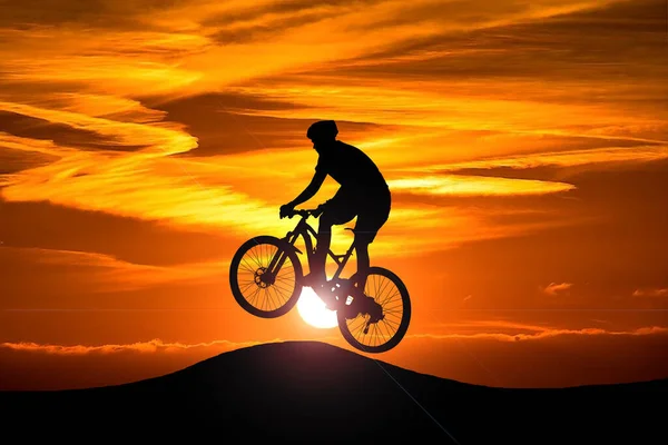 背景に夕日が沈むアクションサイクリストシルエット アクションとアドベンチャースポーツのコンセプト — ストック写真