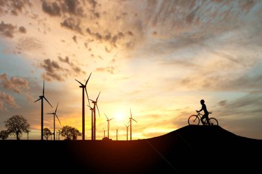 Dünyayı ve çevreyi kurtarmak için temiz enerji kavramı. Rüzgar jeneratörleri ve bisikletçiler