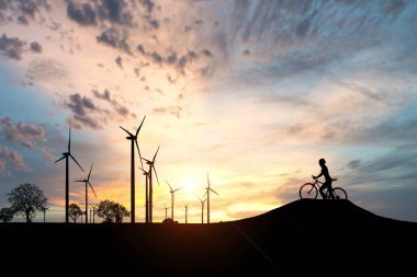 Dünyayı ve çevreyi kurtarmak için temiz enerji kavramı. Rüzgar jeneratörleri ve bisikletçiler